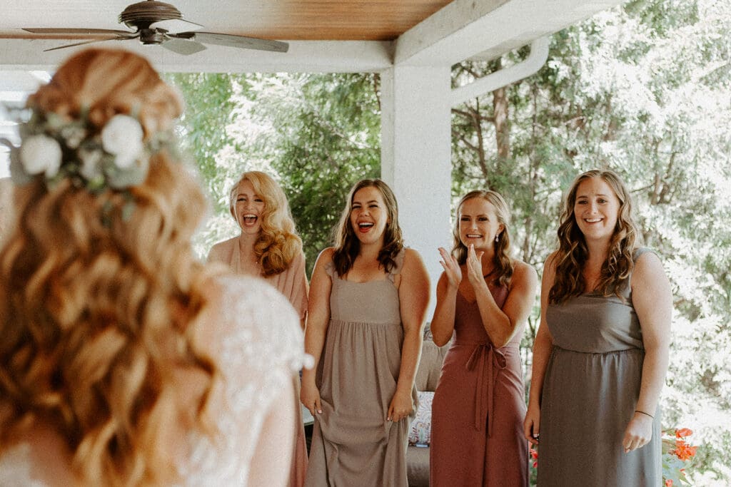 Bridesmaids reacting to the bride's first look reveal before the ceremony