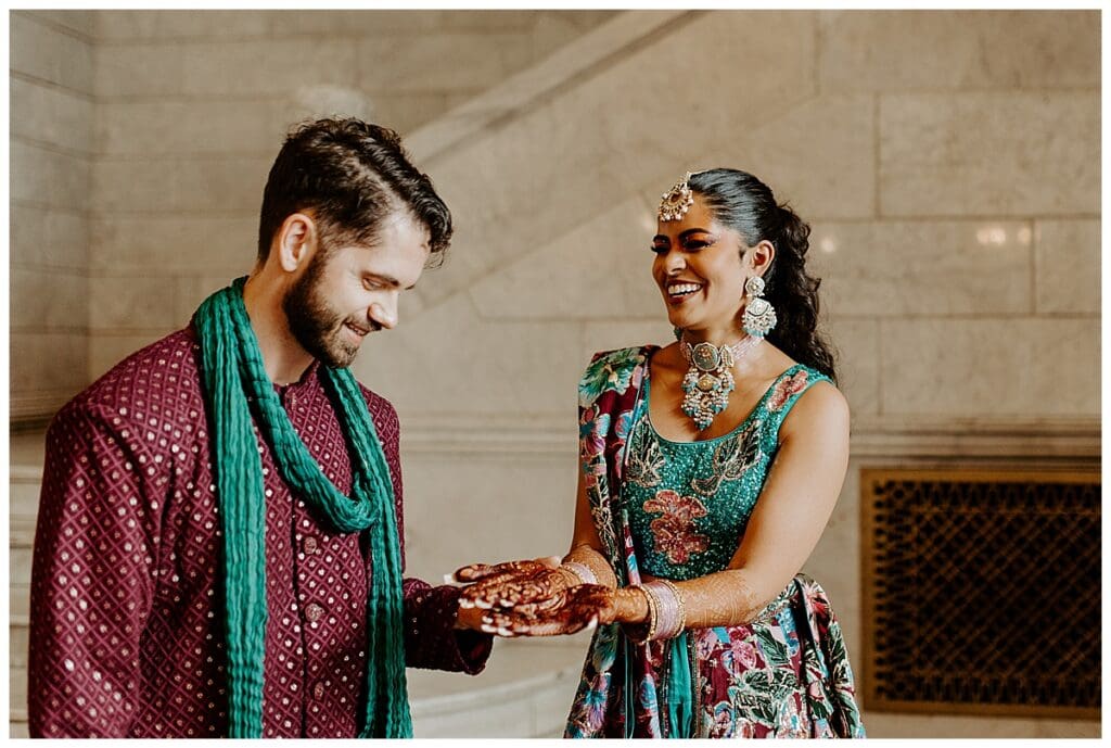 Aarushi showing Shane her henna and laughing before their sangeet celebration at the Lumber Exchange in Minneapolis