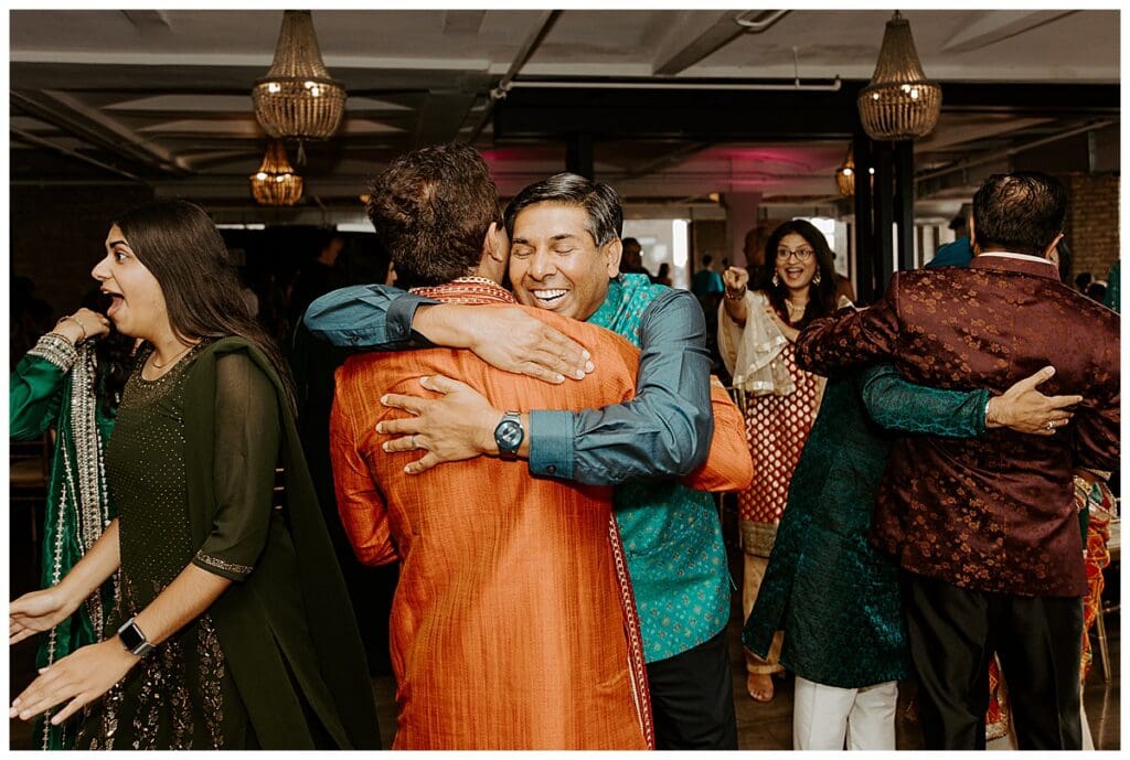 Guests hugging and celebrating at the sangeet during Aarushi and Shane's Indian wedding weekend Minneapolis