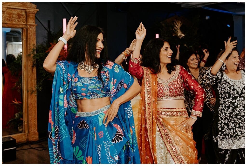 Guests in colorful Indian outfits dancing at the sangeet celebration at the Lumber Exchange Minneapolis