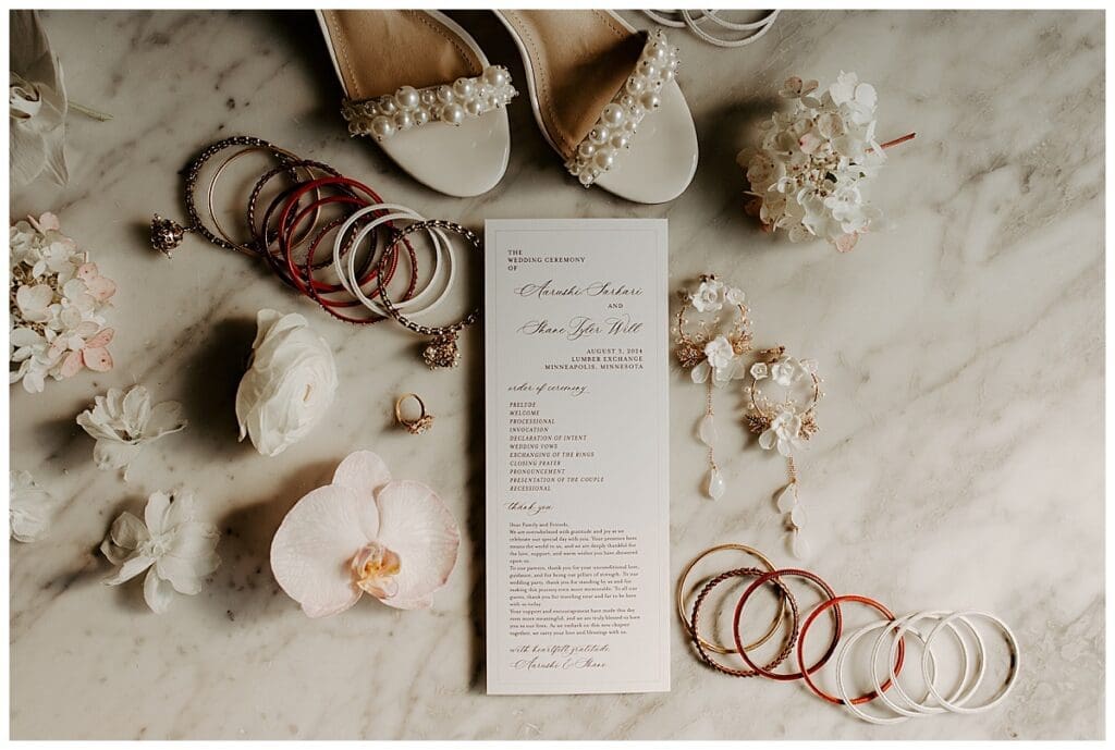 Bridal details flat lay including invitation suite, bangles and shoes for Aarushi and Shane's Minneapolis Indian wedding