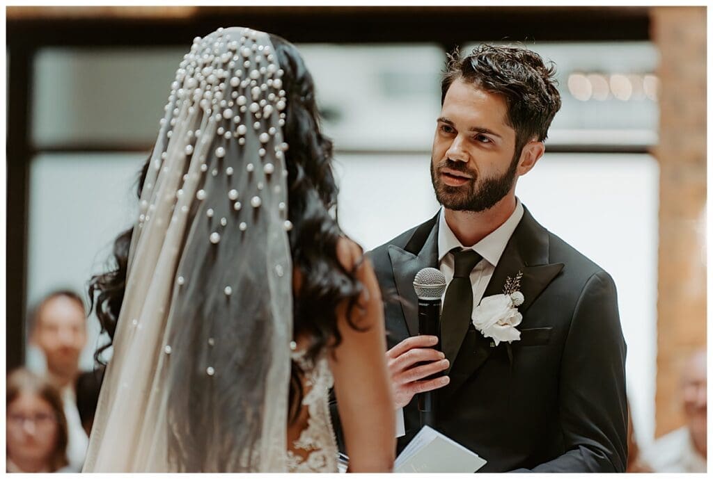 Shane reading his vows to Aarushi during their Christian wedding ceremony at the Lumber Exchange Minneapolis