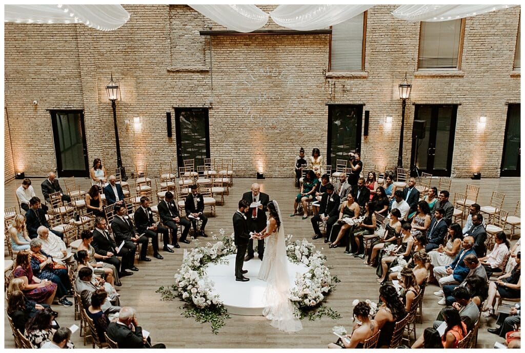 Wide shot of Aarushi and Shane's Christian wedding ceremony inside the Lumber Exchange in downtown Minneapolis