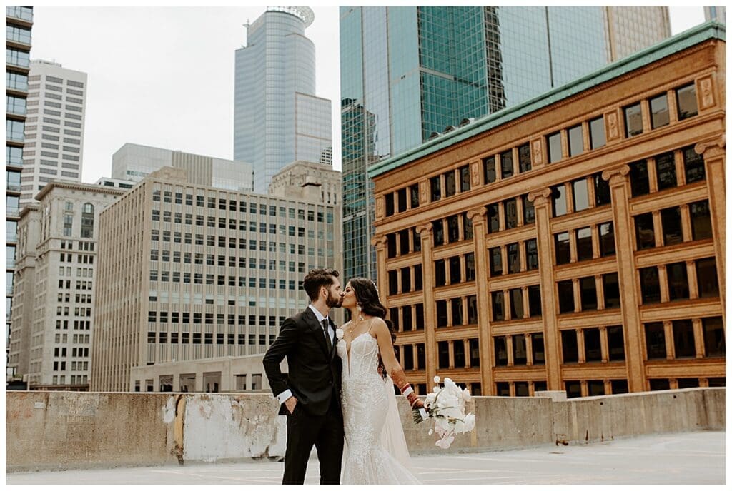 Aarushi and Shane portrait on the rooftop of the Lumber Exchange with the Minneapolis skyline behind them