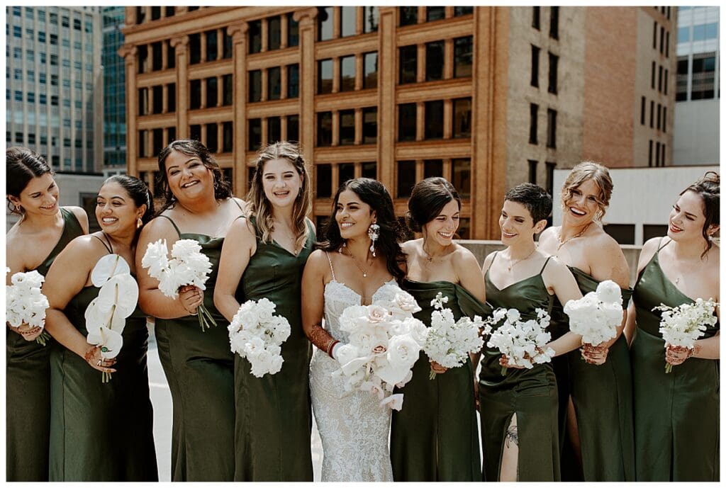 Aarushi and her bridesmaids laughing together on the rooftop of the Lumber Exchange in Minneapolis