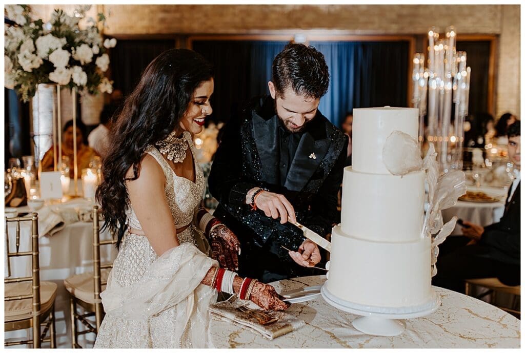 Aarushi and Shane cutting their wedding cake at the reception at the Lumber Exchange in Minneapolis