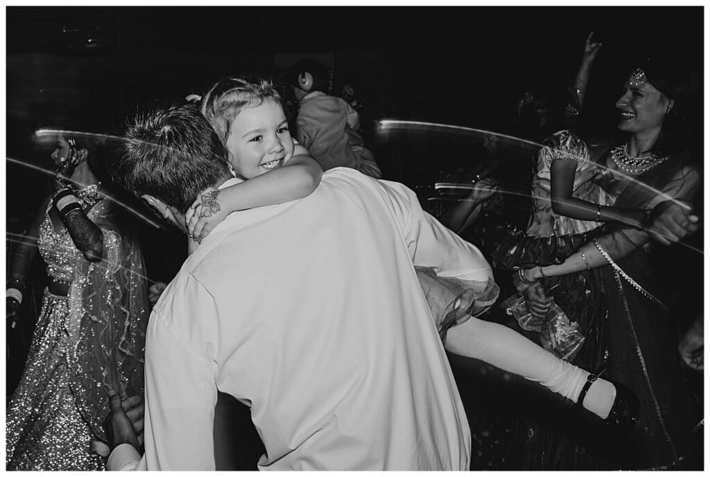Black and white photo of guests dancing at Aarushi and Shane's wedding reception at the Lumber Exchange Minneapolis