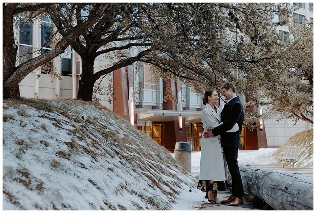 Meredith and Alec walking by a snowy hill during their Minneapolis winter engagement session